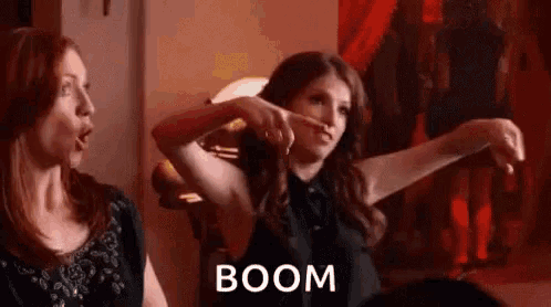 two women are standing next to each other in a room and one of them is making a funny face .