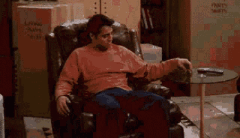 a man is sitting in a chair in front of a box that says living room on it