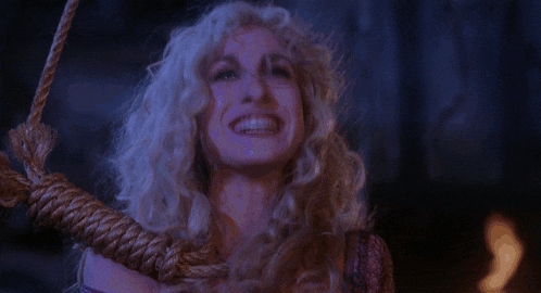 a woman with blonde hair is hanging from a rope