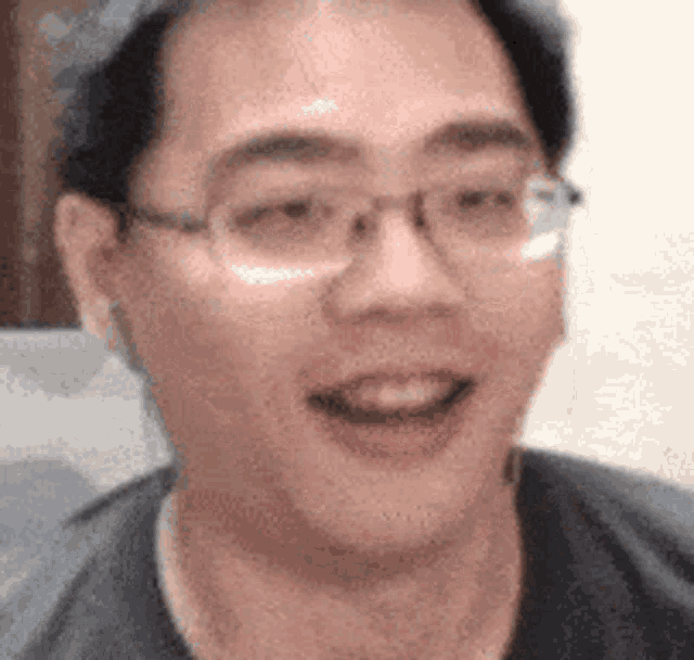 a close up of a man wearing glasses and a black shirt .