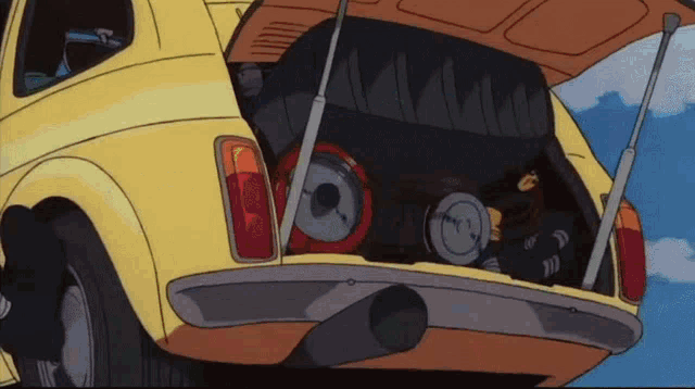 a yellow car with its trunk open and a clock in the back