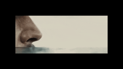a close up of a person 's nose smelling water