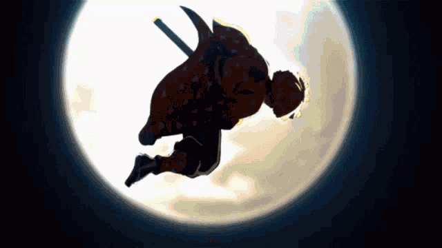 a silhouette of a man with a sword flying through the air in front of a full moon