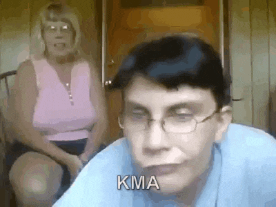 a man wearing glasses and a blue shirt is sitting in front of a woman .