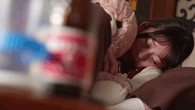 a woman laying on a bed with her eyes closed and a sign in the background that says ' s '