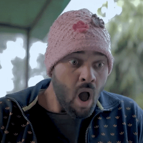 a man with a beard wearing a pink adidas hat
