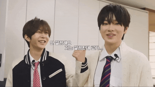 two boys are standing next to each other and one of them is wearing a jacket and tie