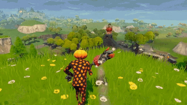 a person with a pumpkin head is standing in a grassy field