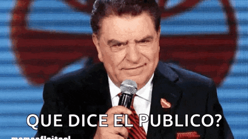 a man in a suit and tie is holding a microphone with the words que dice el publico below him