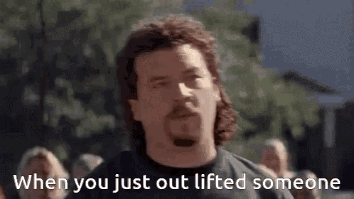 a man with a mullet is standing in front of a crowd and says when you just out lifted someone