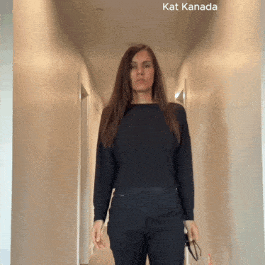 a woman standing in a hallway with kat kanada written on the bottom right