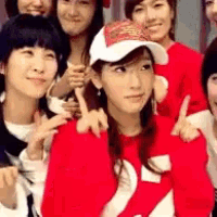 a group of young women are posing for a picture and one of them is wearing a red sweater with the number 22 on it .
