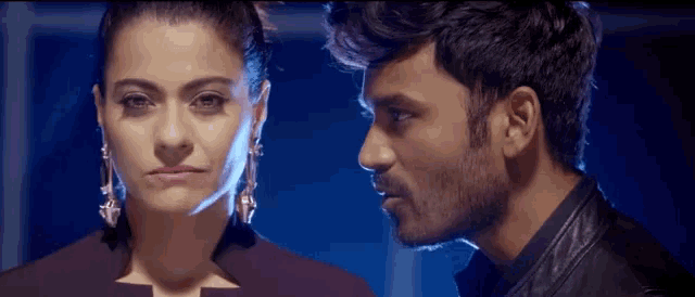 a man and a woman are looking at each other with a blue background