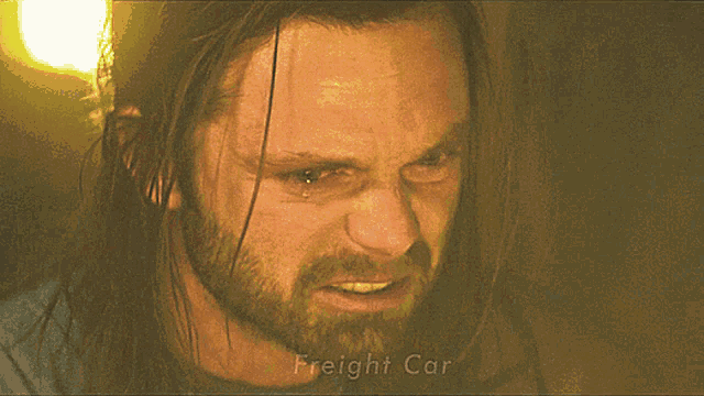 a man with long hair and a beard has a very angry look on his face