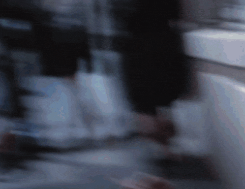 a blurry picture of a person standing in a bathroom