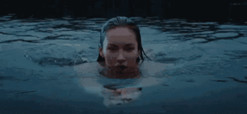 a woman is swimming in a body of water .