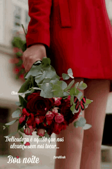 a woman in a red dress is holding a bouquet of red flowers