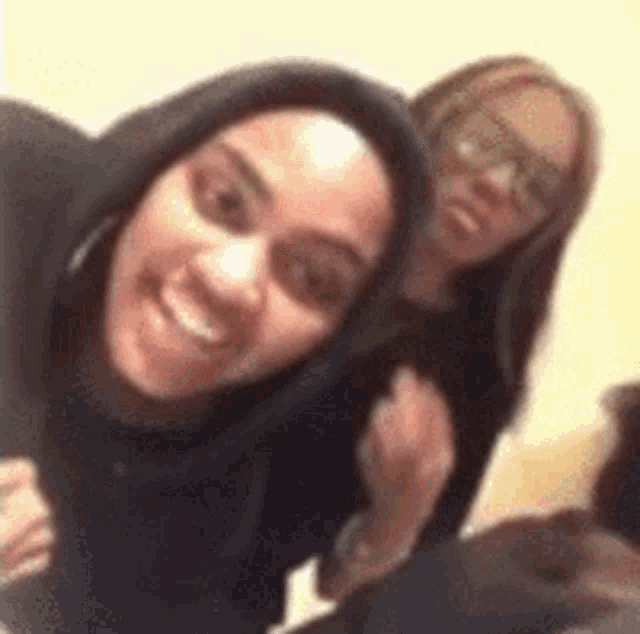 two women are posing for a picture together and smiling .