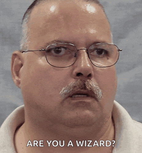 a man with glasses and a mustache asks " are you a wizard "