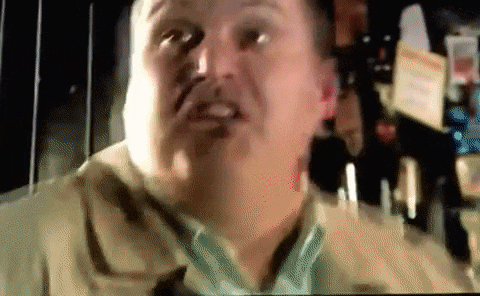 a man is making a funny face while looking at the camera in a blurry photo .