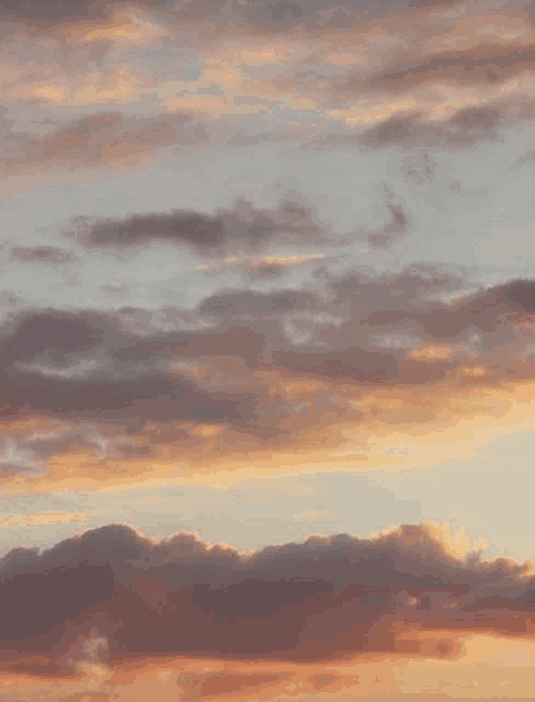 a cloudy sky at sunset with a few pink clouds