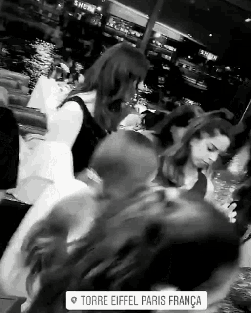 a black and white photo of people in a restaurant with the words torre eiffel paris franca on the bottom