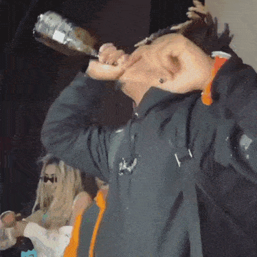 a man is drinking from a bottle with a label on it that says ' smirnoff '