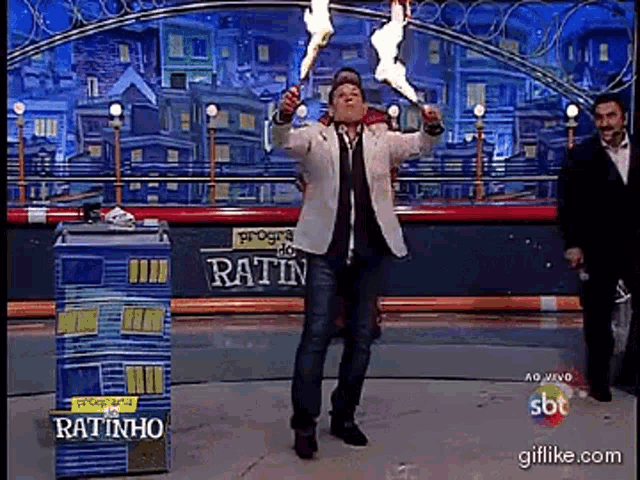 a man is holding a torch in front of a box that says ratinho
