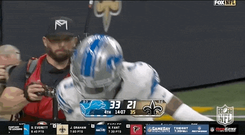a man taking a picture of a football player during a game on fox nfl