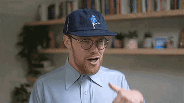 a man wearing a blue hat and glasses is pointing