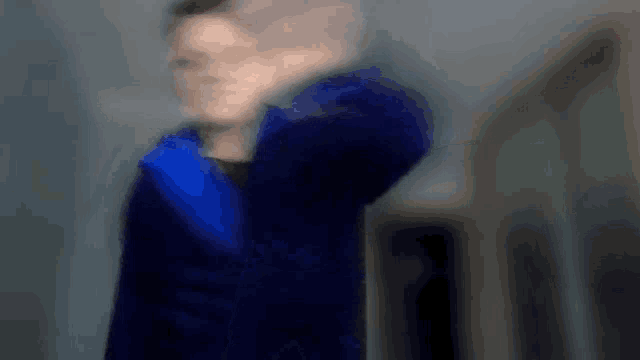 a blurry image of a person in a blue jacket