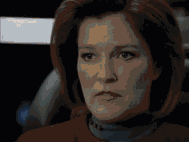 a close up of a woman 's face with a sad look on her face