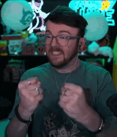 a man with glasses and a beard is wearing a green shirt and a necklace