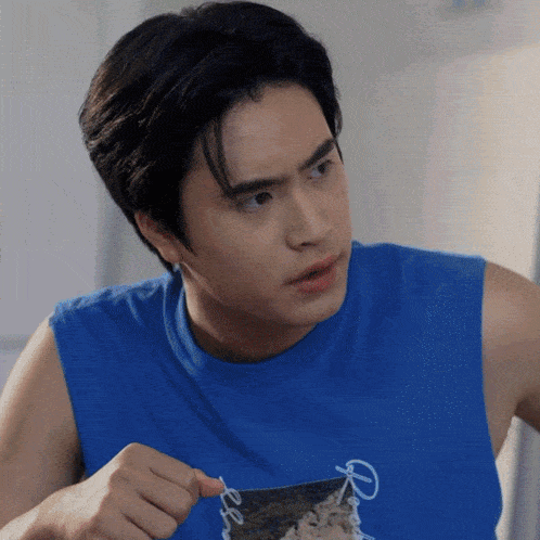 a man wearing a blue shirt with the word peace on it is holding a piece of food