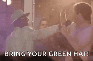 a group of people are dancing in a room with the words `` bring your green hat '' written on the screen .