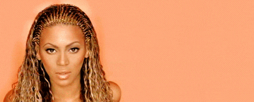 a close up of a woman 's face with braids on her hair
