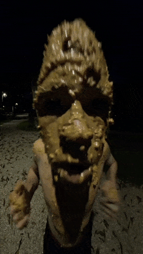 a person with their face covered in peanut butter looks at the camera