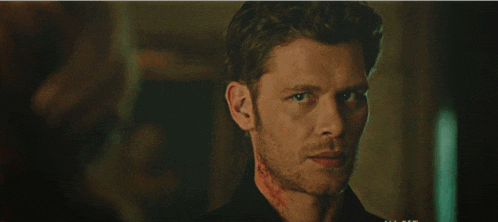 a close up of a man 's face with blood on his neck