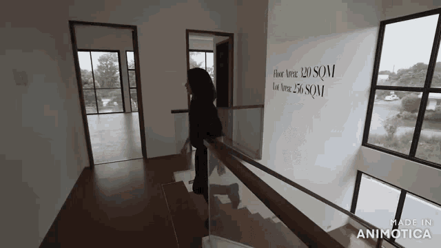 a woman is walking up a set of stairs with a sign that says floor area 120 sqm