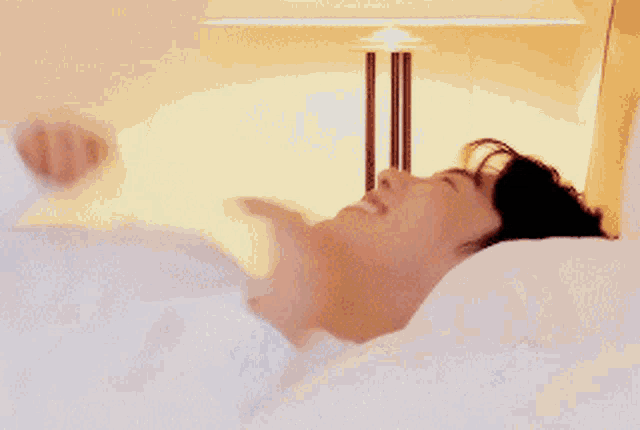 a young man is smiling while laying on a bed