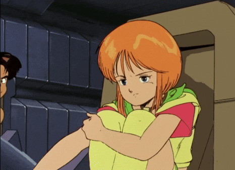 a girl with orange hair is sitting with her arms around her knees