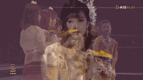 a woman in a white dress is holding a bowl of food in front of her face