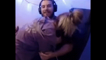 a man wearing headphones is holding a woman 's arm while sitting in a chair .