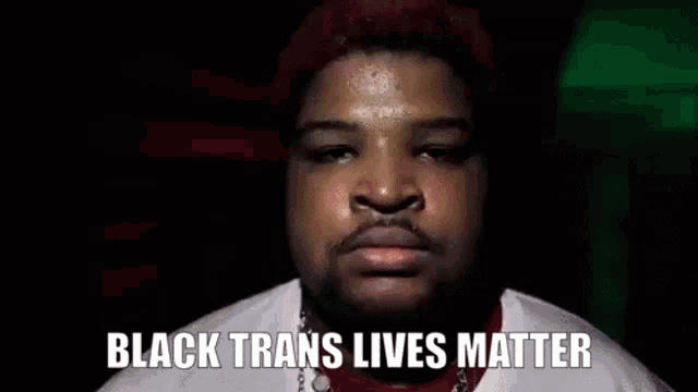 a close up of a man 's face with the words `` black trans lives matter '' written on the bottom .