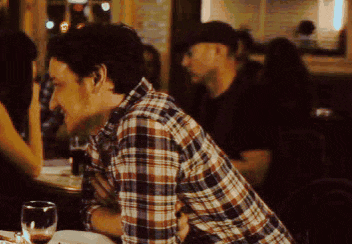 a man in a plaid shirt is sitting at a table