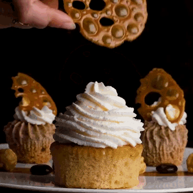 a cupcake with whipped cream on top is on a plate