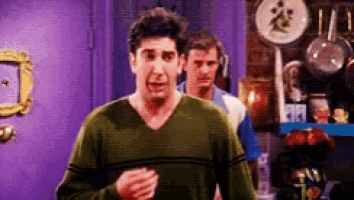 a man in a green sweater is running in a room .