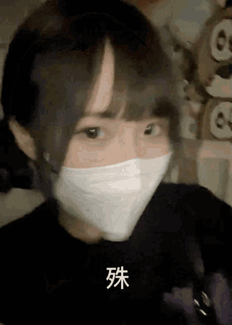 a girl wearing a white face mask with chinese writing on the bottom