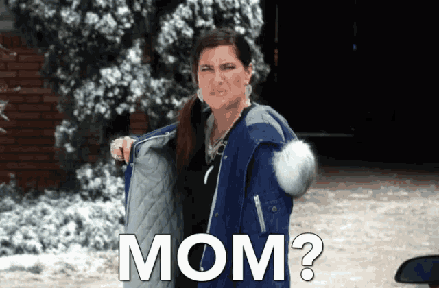a woman wearing a blue jacket is holding her jacket open and says mom