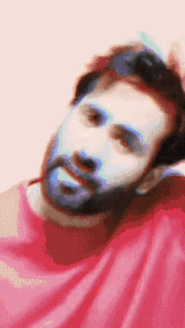 a man with a beard wearing a pink shirt
